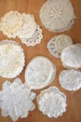 A collection of 20th century crochet doilies, in shades of off-white, having various knot