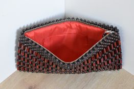 A 1970s wooden beaded clutch bag/purse, featuring red and brown hexagonal carved beads alternating