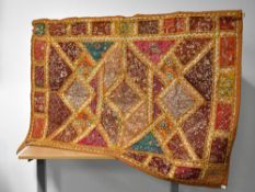 A vintage wall hanging in the African / Middle Eastern style, having yellow-orange, brown, red and
