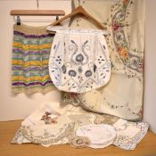 A collection of early-to-mid 20th century domestic linens, comprising two handmade pinafores, an