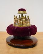 A late Victorian rotating bobbin-stand and pin cushion in purple velvet and brass with a mahogany