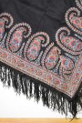 A Victorian silk and wool blend shawl or tablecloth, in black with ornate paisley border, fringing