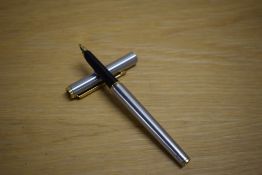 A Parker Arrow aerometric fountain pen in brushed steel with gold trim.