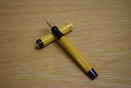 A Parker Duofold vest pocket button fill fountain pen in Mandarin Yellow with three gold bands to