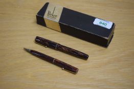 A boxed Parker Moderne button fill fountain pen and Propelling pencil in burgundy marble with blue