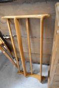 A light Ercol wall mounted plate rack