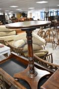 A reproduction Regency occasional table having turned column and platform base