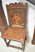 A period oak hall chair in the Continental style having inlaid bird decoration to the back, width