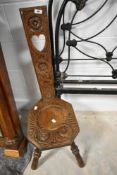 A 19th Century oak spinning chair having typical carved decoration to back and seat, on four