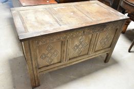 A period oak kist having three carved panels, width approx. 116cm
