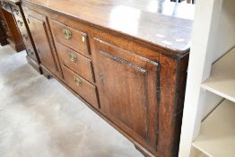 A period oak dresser base having three central drawers flanked by cupboards, width approx. 163cm