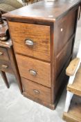 A vintage oak three drawer filing cabinet