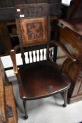 An early 20th Century mahogany carver chair having spindle and tooled leather back with dragon