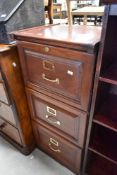 A traditional wooden three drawer filing cabinet
