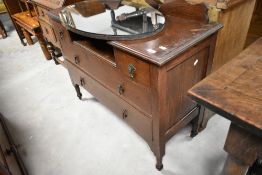 An early 20th Century oak dressing table, arms loose, oval mirror