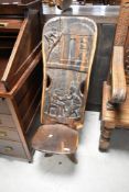 A tribal art carved palaver chair having figural decoration