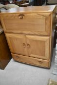 A light Ercol Windsor style bureau/cocktail cabinet, approx. dimensions H110 W82 D44cm