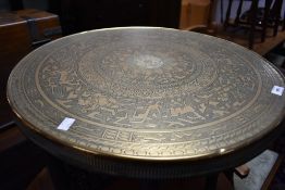 An Indian style brass top table having circular top folding frame, diameter 60cm