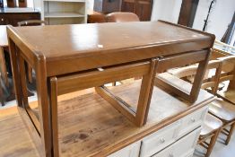 A vintage teak nesting coffee table set, width approx. 96cm