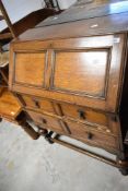An early 20th Century oak bureau on bulbous supports and style frame