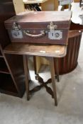 A vintage leather suitcase and an oak occasional table