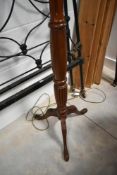A traditional mahogany standard lamp having turned column and triple splay legs