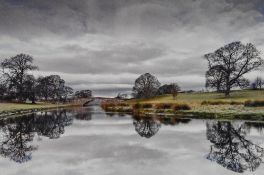 Artist unknown, contemporary photographic print, a river bridge and trees, within black mount and
