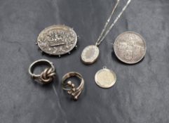 A small selection of silver and white metal jewellery including a knot ring, small locket, St