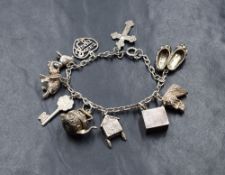 A silver belcher link charm bracelet, having ten silver and white metal charms, including a cross, a
