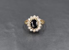 A 9ct gold sapphire and cubic zirconia cluster ring, the central sapphire measuring approximately