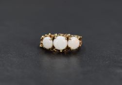 A 9ct gold opal trio ring having three circular opal cabochons in a claw set naturalistic mount on a