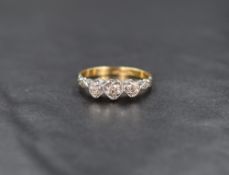 An 18ct gold and platinum diamond trilogy ring, the illusion set diamond chips within heart motifs
