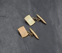 A pair of gold cufflinks, the rectangular panels having engine turned decoration with a chain link