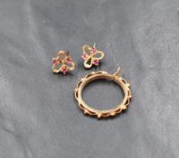 A pair of 9ct gold and ruby stud earrings, the pierced floral motif earrings set with three round