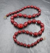 A long graduated red bead necklace thought to be cherry amber, the beads measuring between