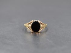 A 9ct gold signet ring having an oval onyx panel in a collared mount to split shoulders, size Q &