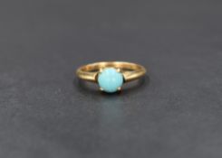 A yellow metal (presumed gold) turquoise ring, the circular turquoise cabochon in a four claw