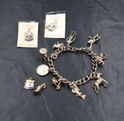 A silver charm bracelet, having nine white metal charms including a rabbit, a Norman soldier and a