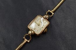 A 9ct gold Rotary wristwatch, the rectangular champagne dial having Arabic and dot numerals, on a