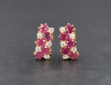 A pair of large yellow metal ruby set loop and post earrings stamped 750, each earring having four