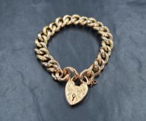 A 9ct rose gold curb link bracelet, having a heart padlock with decorative scroll engraving and