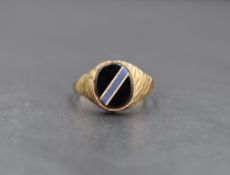 A 9ct gold signet ring, the oval onyx panel having a blue stone and gold diagonal inlay, with