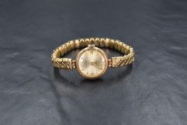 A 9ct gold Rotary wristwatch, the champagne dial having Arabic and baton numerals, on a 9ct gold