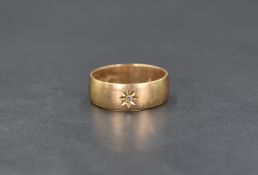 A 9ct gold band, having a central diamond chip in a star burst setting, ring size R-S, 4.7g