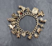 A silver charm bracelet having padlock clasp and sixteen charms including church, holy bible, boot