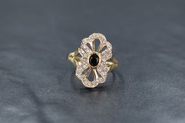 A 9ct gold sapphire and diamond plaque ring, the central oval cut bezel set blue sapphire in a