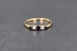 A 9ct gold five stone sapphire & diamond ring having a claw set mount and shaped shoulders to