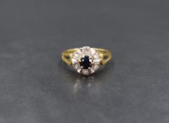 An 18ct gold sapphire and diamond ring, the central round cut blue sapphire measuring