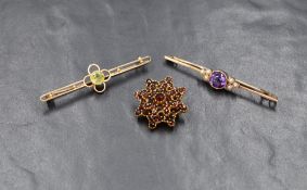 Two yellow metal bar brooches stamped 15ct, one having a central peridot in an open mount, the other