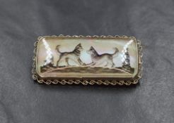 A rectangular mother of pearl brooch depicting a pair of husky dogs in Northern Light style
